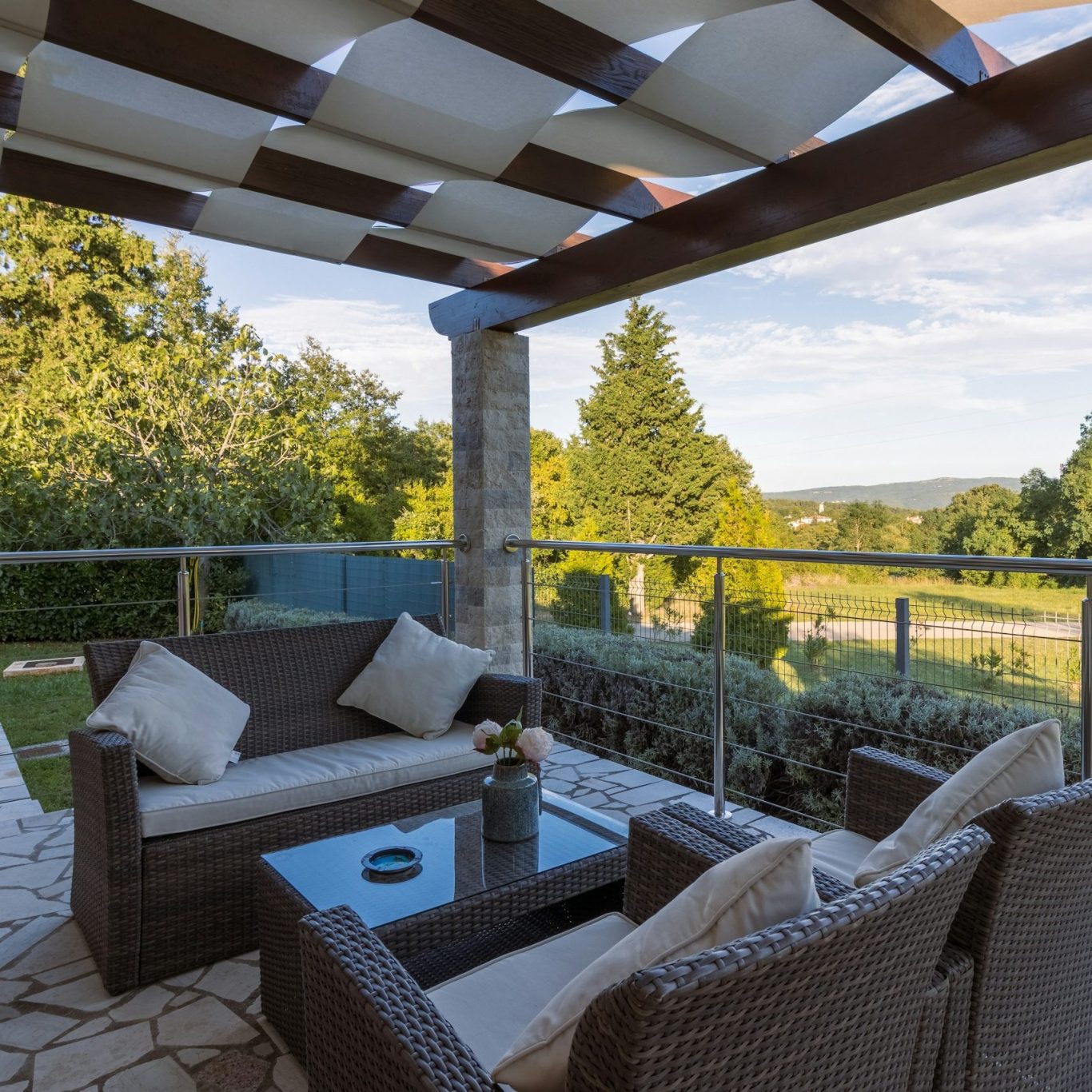 Symbolbild: Überdachte Terrasse mit Sitzbereich und Blick ins Grüne